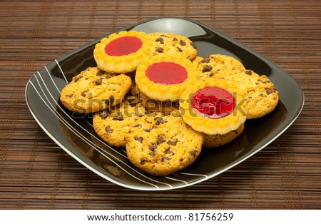 A plate of cookies on dark brown background