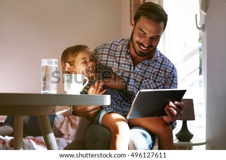 Little girl spending time with her father at home.