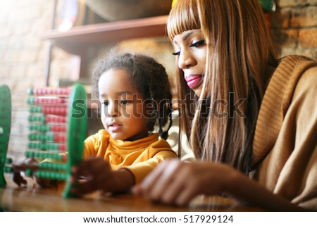 Mother teaching daughter to accounting.
