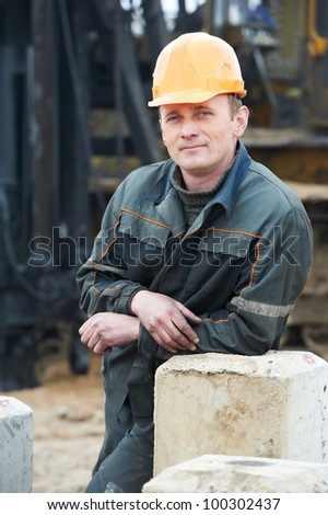 Smiling Builder repairman worker in dirty workwear at construction site