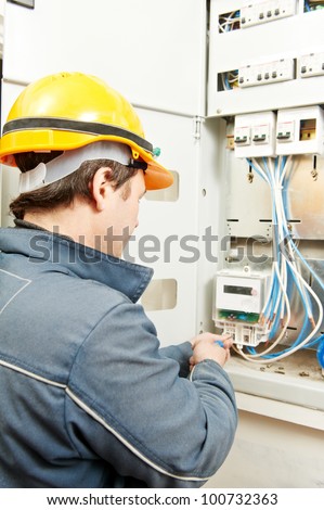 One electrician builder at work installing energy saving meter into electric line distribution fuseboard