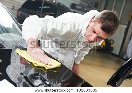 auto mechanic worker polishing car bonnet with wiper at automobile repair and renew service station shop auto mechanic worker polishing car bonnet with wiper at automobile repair and renew service station shop