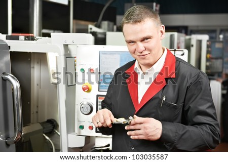 mechanical technician worker measuring detail tool after processing on cutting machine center at workshop with sliding caliper