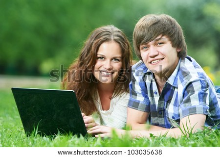 Group of two young students studying with computer in spring outdoors