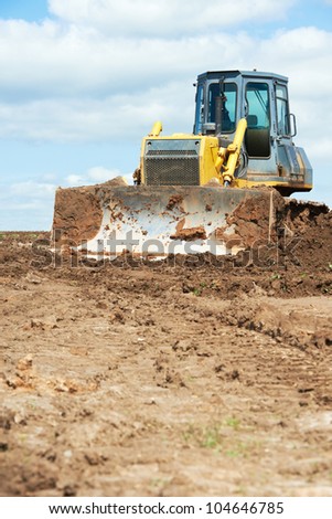 track-type loader bulldozer excavator machine doing earthmoving work at sand quarry