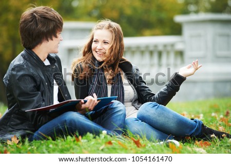Happy college students on campus lawn outdoors