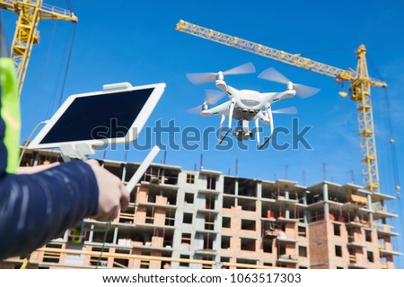 Drone operated by construction female worker on building site