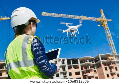 Drone inspection. Operator inspecting construction building site flying with drone