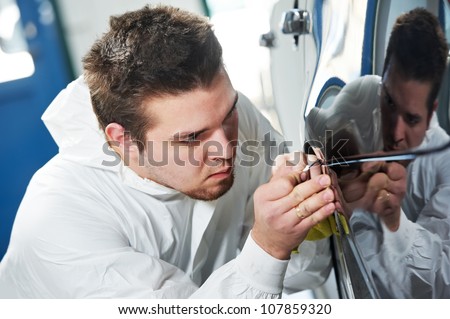 auto mechanic worker painting element car at automobile repair and renew service station shop by power buffer machine