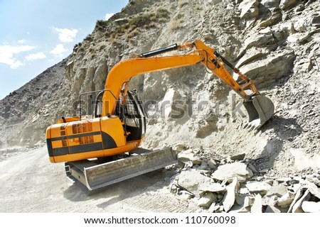 track-type loader excavator machine doing earthmoving roadwork at mountain