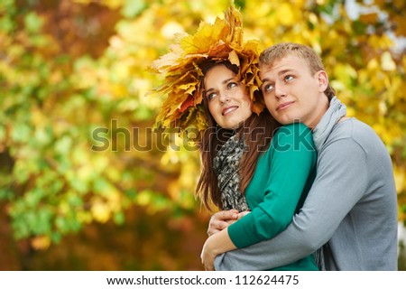 Two Smiling young attractive people with autumn maple leaves in park at fall outdoors date