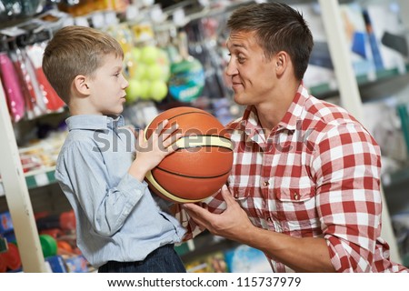 Family Shopping. Young Father With Son Choosing Sport Equipment Basket Ball At Supermarket