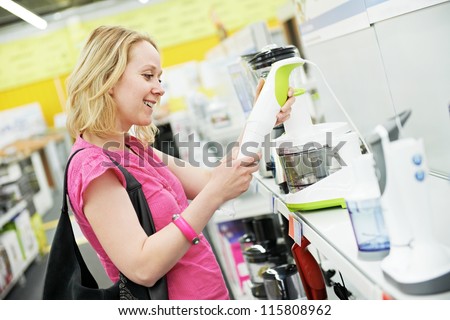 Young woman choosing kitchen mixer blender in home appliance shopping mall supermarket