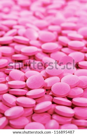 Pharmacy theme, Heap of pink round medicine tablet antibiotic pills. Shallow DOF