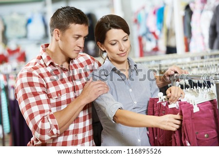 Young man and woman family choosing outerwear during clothing shopping at supermarket store