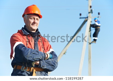 Portrait of electrician lineman repairman worker on electric post power pole line work