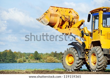 heavy wheel loader excavator machine loading sand at quarry