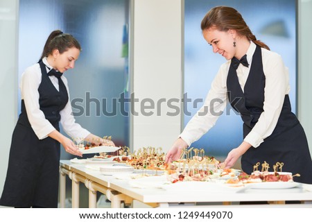 Catering. Restaurant waitress serving table with food