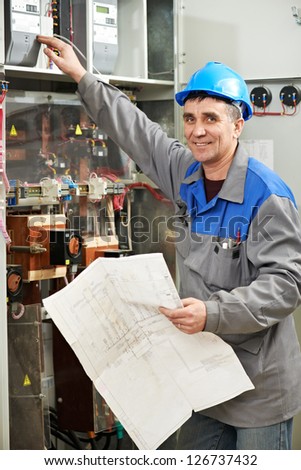 Smiling electrician at work checking wire with drawing inspecting high voltage power electric line distribution fuseboard
