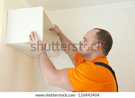 Craftsman carpenter at kitchen cabinet installation service work