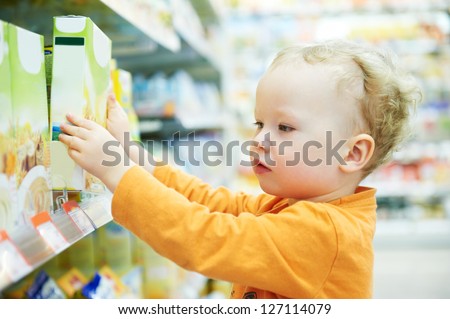 One little child choosing produces during food shopping in grocery store supermarket