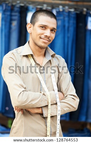 Portrait of one Indian tailor trade seller man with measure tape outdoors