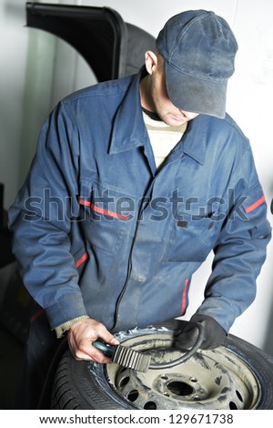 mechanic repairman making tyre fitting with compressed air