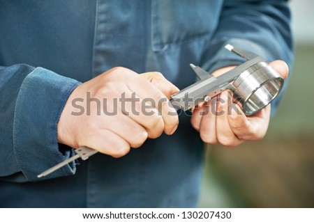 mechanical technician worker hands measuring detail tool after processing at workshop with sliding caliper at manufacturing