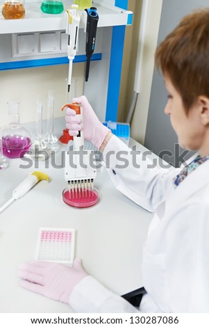 Female Adult Researcher woman with dropper of medicine during pharmaceutical laboratory blood test examination