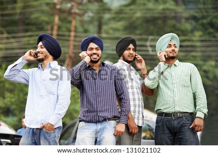 stock-photo-group-portrait-of-smiling-authentic-native-indian-punjabi-sikh-men-in-turban-speaking-on-mobile-131021102.jpg