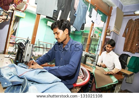 Portrait of two indian man tailor at work place with sewing machine