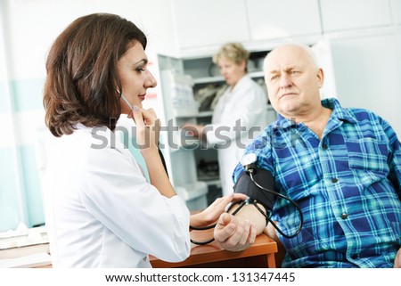 doctor measuring blood pressure of patient by phonendoscope in clinic hospital