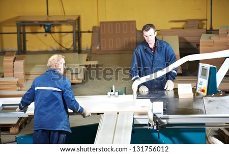 technician workers with circ saw machine at wood furniture manufacturing workshop production