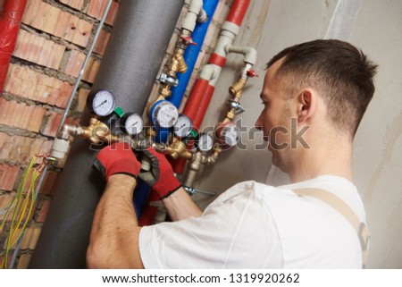 plumber installing and mounting water equipment - meter, filter and pressure reducer