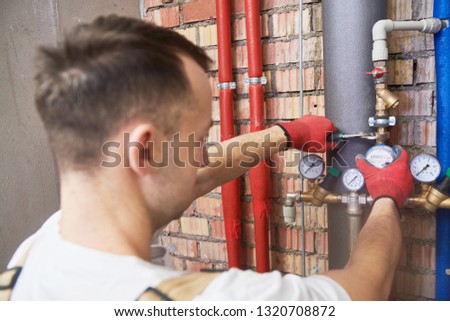 plumber installing and mounting water equipment - meter, filter and pressure reducer