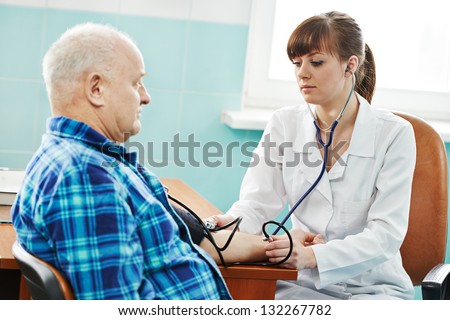 doctor nurse measuring blood pressure of patient by phonendoscope in clinic hospital