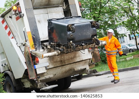 Worker Of Municipal Recycling Garbage Collector Truck Loading Waste And Trash Bin