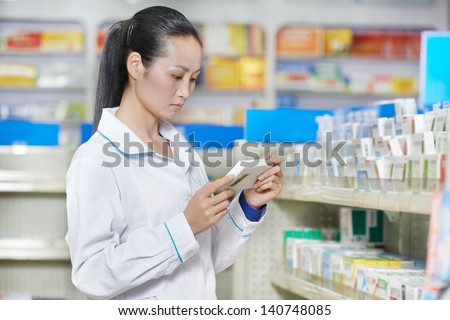 chinese pharmacist chemist woman choosing tablets in china pharmacy drugstore