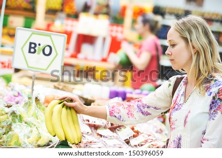 Shopping. Young woman buyng bio food fruit in vegetable store or supermarket