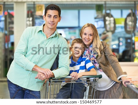 Family shopping. Young man and woman with child during shopping at supermarket store