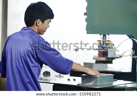 chinese worker operating press in china production factory manufacturing