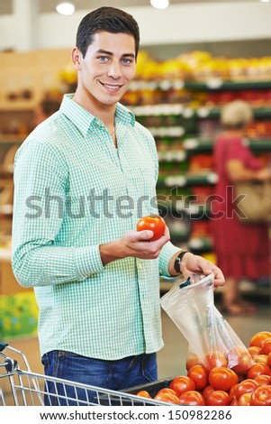 Young man shopping tomato food in vegetable store or supermarket