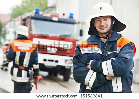 Fireman in uniform in front of fire engine or fire truck during training