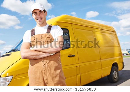 Smiling young male delivery courier man in front of cargo van for delivering or relocation
