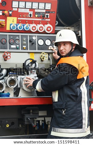Fireman in uniform operating fire engine or fire truck on duty during training