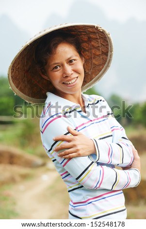 Portrait of smiling chinese asian woman worker at farm work gathering citrus oranges in agriculture fruit garden