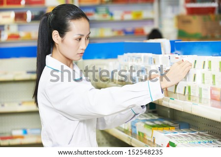 chinese pharmacist chemist woman choosing tablets in china pharmacy drugstore