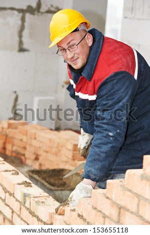 Portrait of construction mason worker bricklayer with trowel putty knife outdoors at building area