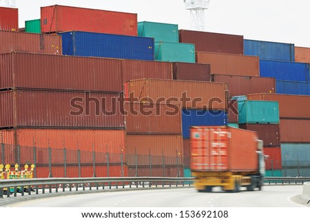 Lorry handling container box at motion in front of sea port cargo warehouse dock terminal