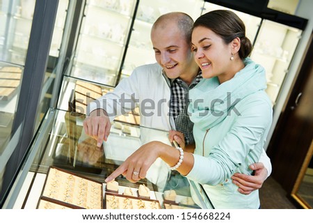 Young happy couple together selecting gift at jewelry boutique shop